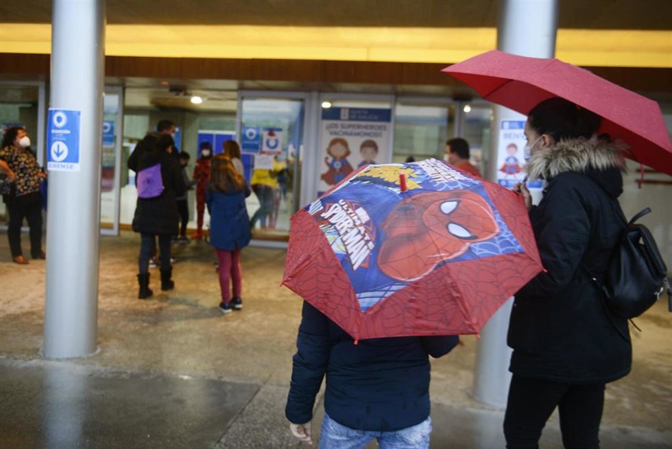 Archivo - Varios niños acompañados de sus padres, a su llegada al recinto ferial Expourense para ser vacunados
