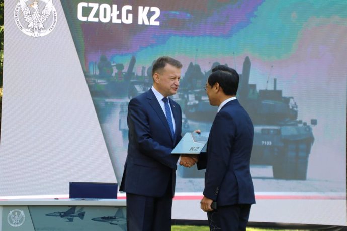 27 de julio de 2022, Polonia, Varsovia: El viceprimer ministro y ministro de Defensa polaco, Mariusz Blaszczak (izq.), estrecha la mano de Lee Yong-bae, presidente y director general de Hyundai Rotem Co, durante la ceremonia de la firma del acuerdo