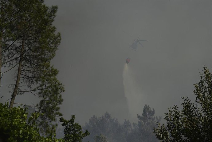 Un helicóptero trabaja en la extinción de un incendio, a 27 de julio de 2022, en Castrelo de Miño, Ourense, Galicia (España). El incendio forestal ha quemado unas seis hectáreas, según estimación provisional de Medio Rural. La Consellería informa que el