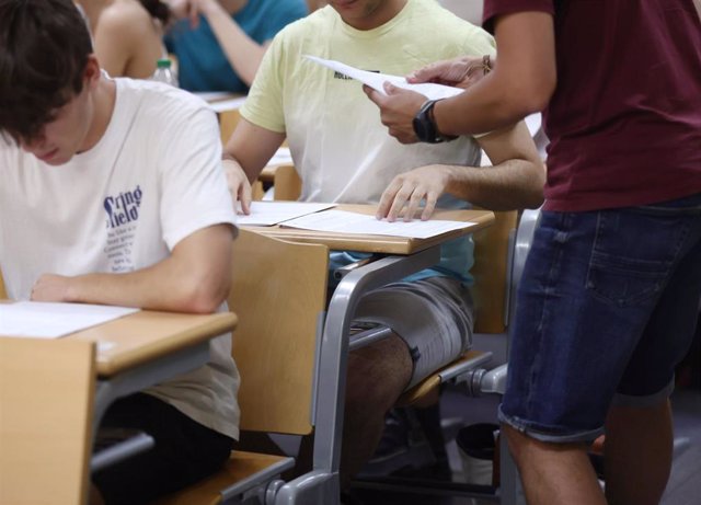 Un profesor reparte los exámenes de la convocatoria extraordinaria de la Evaluación para el Acceso a la Universidad (EvAU) a los estudiantes, en la Facultad de Matemáticas de la Universidad Complutense de Madrid, a 5 de julio de 2022, en Madrid (España).