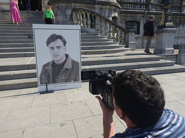 Un cámara de televisión graba un cartel con la fotografía de Miguel Ángel Blanco en una concentración de homenaje a su persona y otras víctimas celebrado en Bilbao.