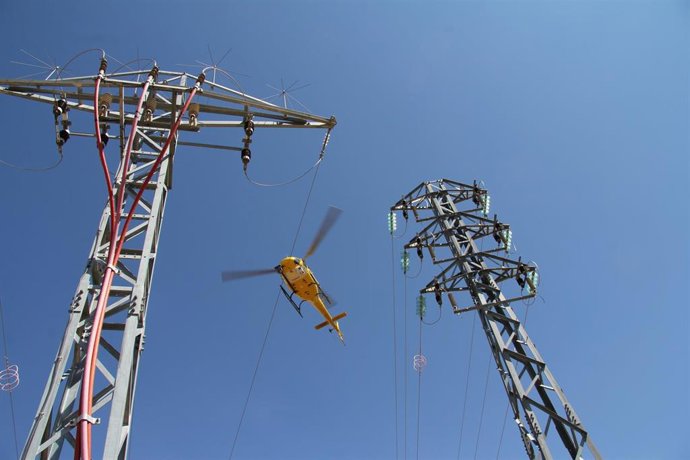 Archivo - Revisión de líneas de alta tensión con un helicóptero.