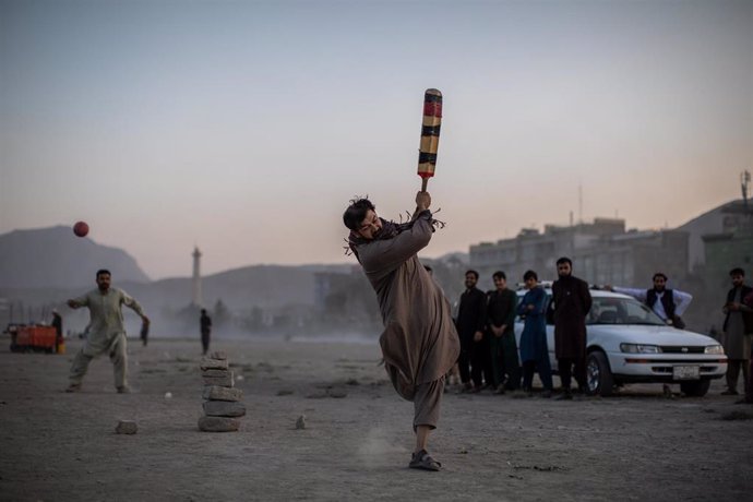 Archivo - Un hombre juega al cricket en Kabul, Afganistán.