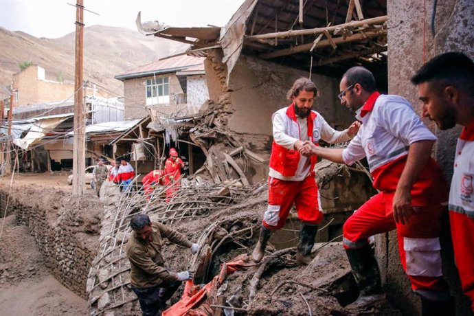 29 July 2022, Iran, Tehran: Rescue members work at a damaged area in the northwestern part of Tehran after flash floods caused by Heavy rains in the early hours of Thursday. At least eight people died, and some are still missing. Photo: -/Iranian Red Cr