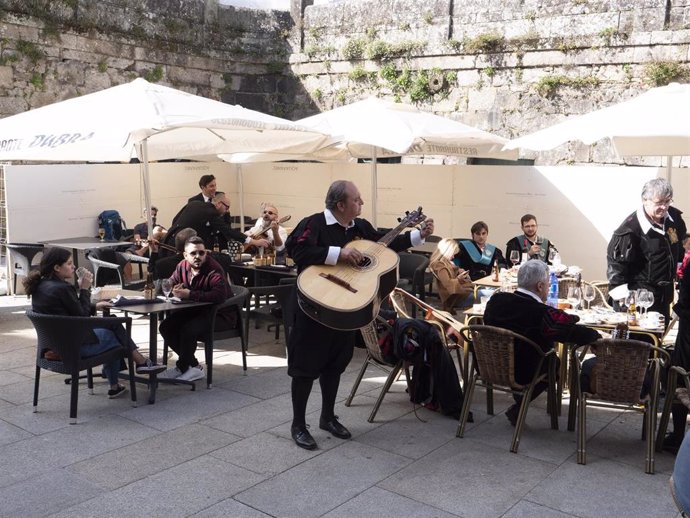 Archivo - Un tuno afina un instrumento en la terraza de un bar en Santiago de Compostela, a 9 de octubre de 2021, en Santiago de Compostela.