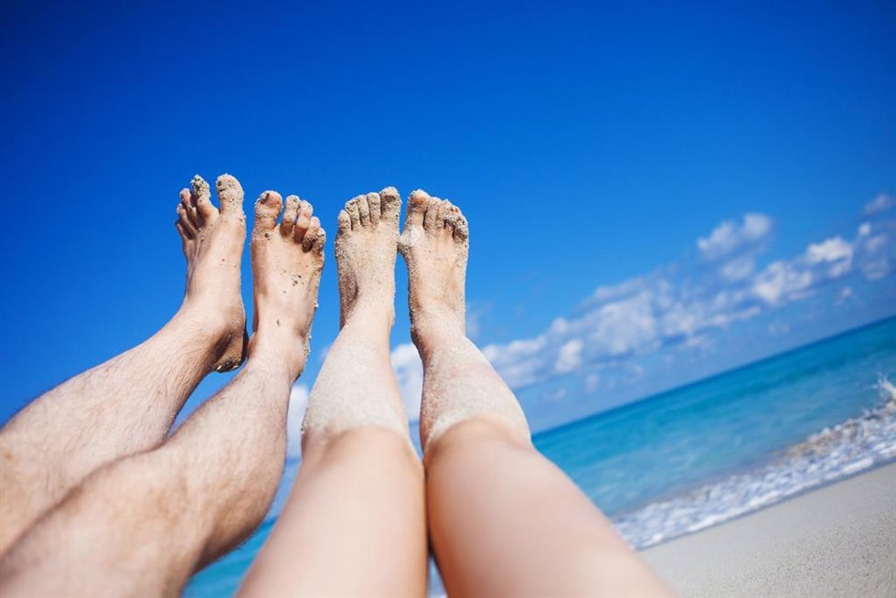 Archivo - Piernas de una pareja en la playa.