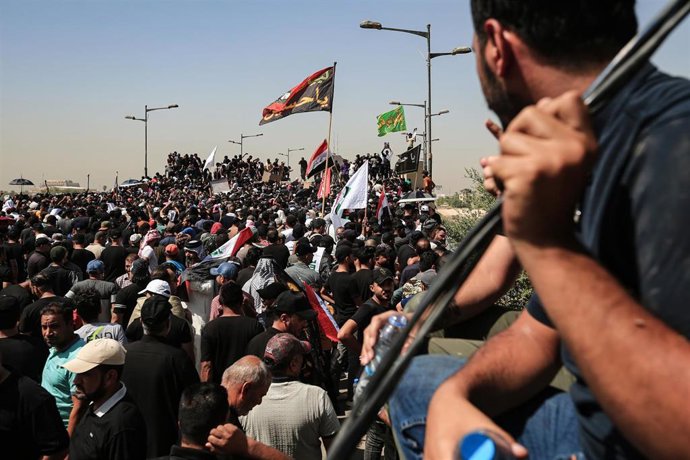 30 July 2022, Iraq, Baghdad: Supporters of Iraq's influential Shiite cleric Moqtada al-Sadr tear down the concrete barriers on Al-Jumhuriya bridge before storming into the Green Zone to break into the Iraqi Parliament building for the second time this w