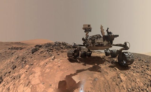 El rover Curiosity Mars de la NASA tomó este autorretrato de ángulo bajo en el sitio donde perforó una roca el 30 de julio de 2015, produciendo un polvo (visible en primer plano) que luego se confirmó que contenía el raro mineral tridimita.