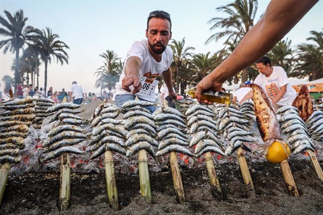 Un espetero ante una barca con espetos de sardinas, producto típicamente malagueño que celebrará su concurso anual al mejor espetero en agosto en Torremolinos