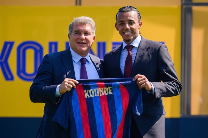 The president of FC Barcelona, Joan Laporta (L) and French footballer Jules Kounde hold his new jersey during a press conference to unveil joining FC Barcelona at Ciutat Esportiva Joan Gamper