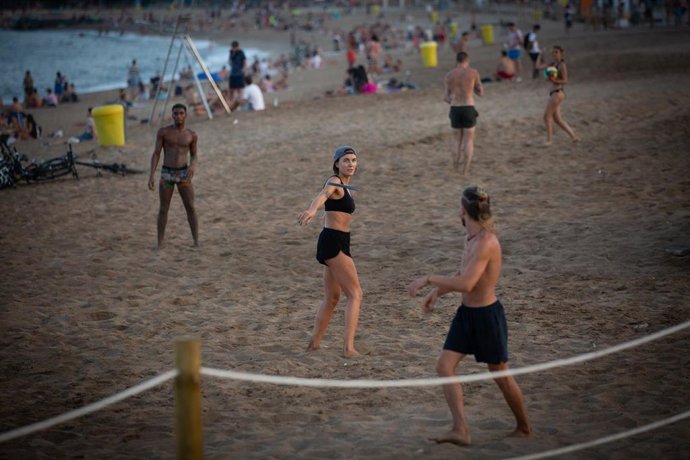 Archivo - Bañistas juegan en la playa en Barcelona