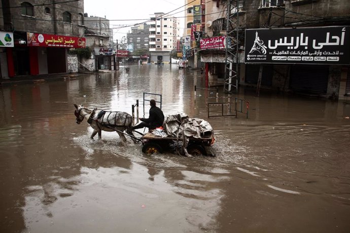 Archivo - 17 December 2020, Pakistan, Jabalia: A Palestinian man rides a donkey-drawn cart through a street flooded with rain water at the Jabalia refugee camp. Photo: Mohammed Salem/APA Images via ZUMA Wire/dpa