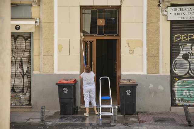 Una treballadora neteja un portal, a 28 de juliol de 2022, a Madrid (Espanya). 