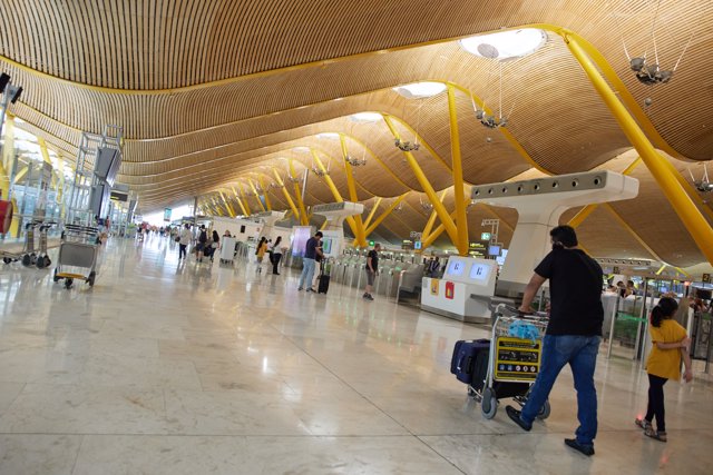 Un hombre con un carro con maletas en la terminal T4 del aeropuerto Adolfo Suárez Madrid-Barajas, a 11 de julio de 2022, en Madrid