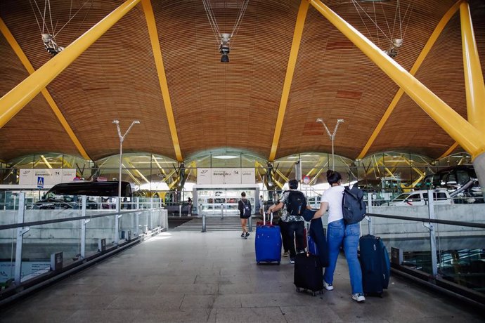 Archivo - Pasajeros con sus maletas en la Terminal 4 del Aeropuerto Adolfo Suárez Madrid Barajas