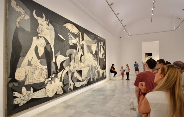 Archivo - Asistentes observan el cuadro del Guernika tras una acción por la paz de activistas, en el Museo Reina Sofía, a 27 de junio de 2022 