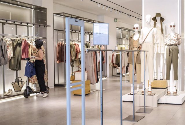 Archivo - Una dependienta de una tienda de ropa 
