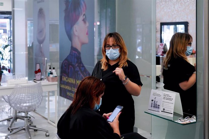 Archivo - Una clienta de la peluquería Encarna Moreno, sin mascarilla en el día en que ha entrado en vigor el decreto que pone fin al uso de la mascarilla en la mayoría de interiores a 20 de abril del 2022 en Sevilla (Andalucía, España). Desde hoy, 20 d