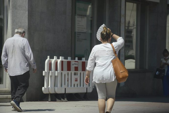 Dos personas caminan por una vía en plena ola de calor, a 12 de julio de 2022, en Orense, Galicia (España). Los termómetros de la práctica totalidad del territorio gallego alcanzarán valores extremos debido a la ola de calor que comenzó la semana pasa