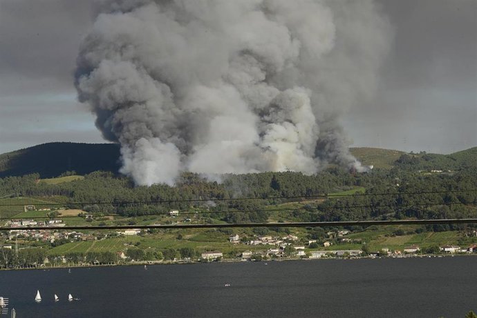 Vista del incendio desde Sampaio, al otro lado del río, a 27 de julio de 2022, en Castrelo de Miño, Ourense, Galicia (España). El incendio forestal ha quemado unas seis hectáreas, según estimación provisional de Medio Rural. La Consellería informa que e