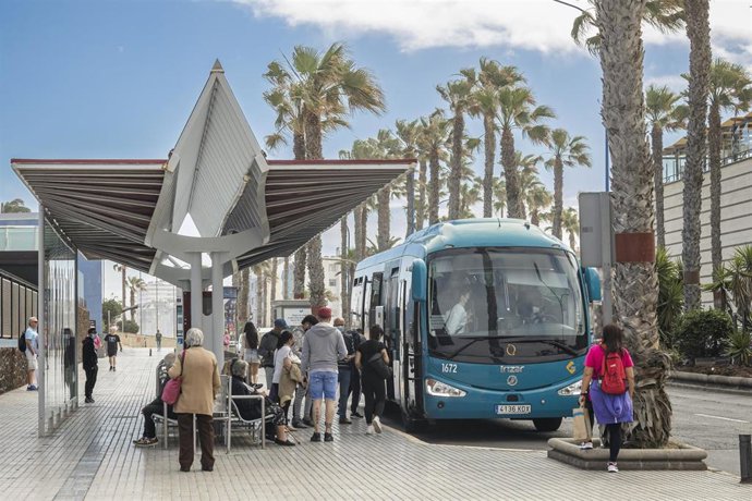 Archivo - Usuarios hacen cola para subirse a una guagua de la compañia Global