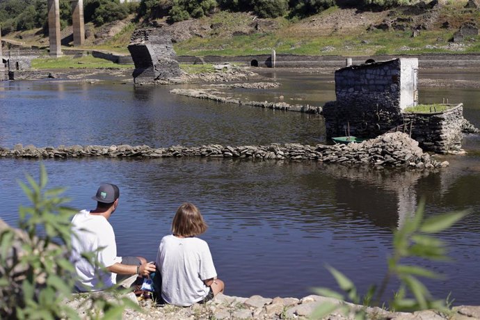 Dos peregrinos observan las ruinas del viejo Portomarin, a 27 de julio de 2022, en Lugo, Galicia, (España). La costa gallega lleva en prealerta por sequía meteorológica desde el pasado 7 de febrero. Además, los embalses españoles están al 45,3% de su ca