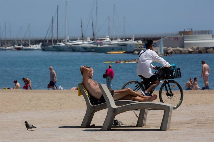 Varias personas toman el sol en la playa de la Barceloneta, a 13 de julio de 2022, en Barcelona, Catalunya (España). 