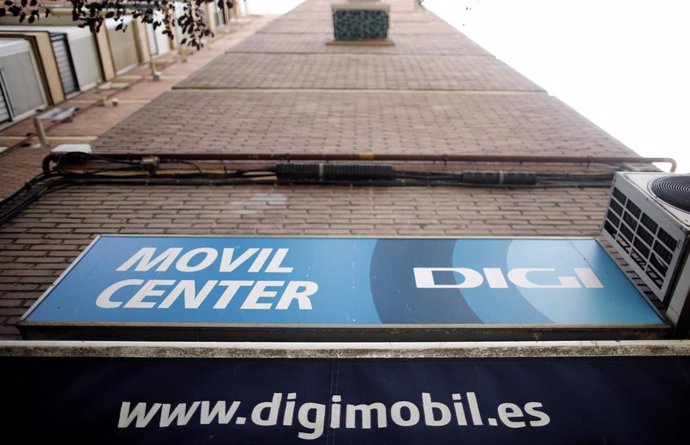 Archivo - Cartel de una tienda del servicio de telefonía Digi Mobil en el que se lee 'Movil Center DIGI'. Debajo un toldo con la dirección web de la empresa.