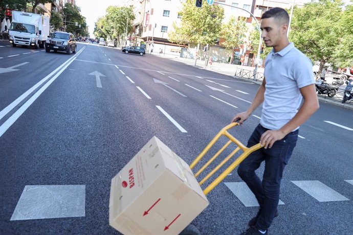 Archivo - Un hombre traslada una caja con material en una carretilla, en una imagen de archivo.