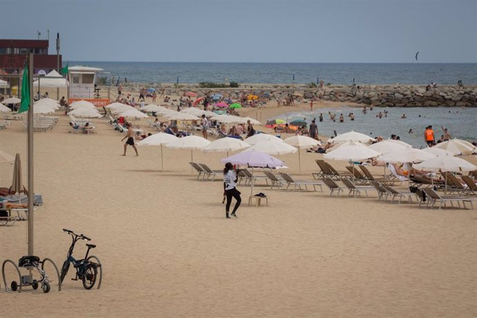 Bañistas en la playa del Bogatell, a 25 de julio de 2022, en Barcelona, Catalunya (España). 