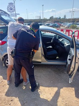 Un agente de la Policía Nacional en Palma, junto a uno de los detenidos.