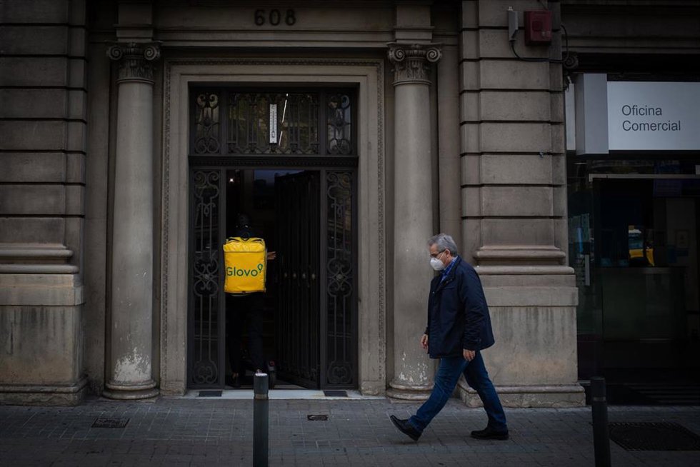 Archivo - Un trabajador de Glovo entra en un portal durante el tercer día de la entrada en vigor de las nuevas restricciones en Cataluña, en Barcelona, Cataluña (España) a 19 de octubre de 2020.