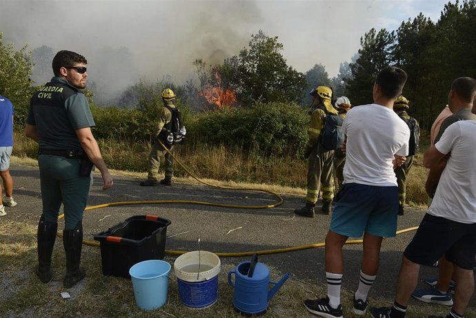 Varias personas trabajan en la extinción de un incendio en Verín, a 2 de agosto de 2022, en Verín, Ourense, Galicia (España). Un incendio forestal que permanece activo desde las 14,52 horas de este miércoles en Verín (Ourense) ha obligado a activar la a
