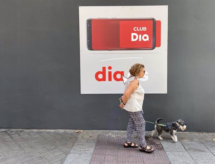 Archivo - Una mujer camina frente a un supermercado Dia