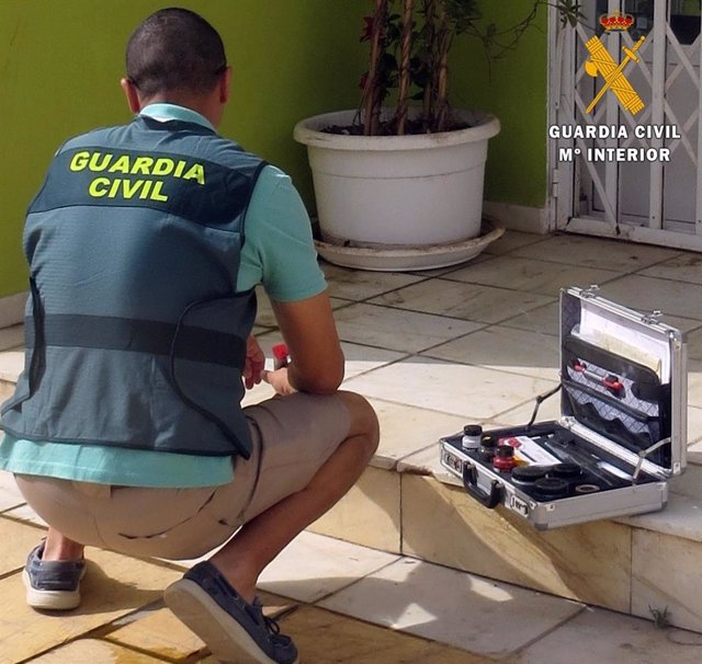 Un agente de Guardia Civil recoge vestigios del apuñalamiento de un hombre a las puertas de un club cannábico de Almería.