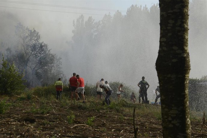 Varias personas trabajan en la extinción de un incendio en Verín. 