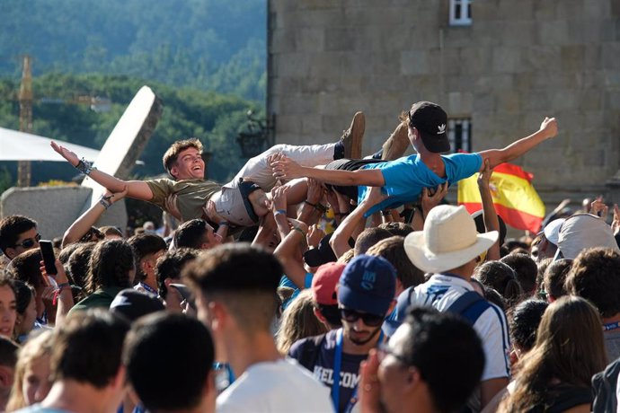 Dos jóvenes son levantados en brazos durante la inauguración y acto de acogida de la peregrinación europea de jóvenes 2022, en el Obradoiro de Santiago, a 3 de agosto de 2022, en Santiago de Compostela, A Coruña, Galicia (España). La Peregrinación Europ