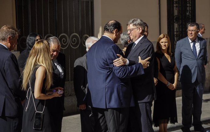 Uno de los hijos de Santiago Grisolía (i), saluda al presidente de la Generalitat valenciana, Ximo Puig (d), a su llegada a la capilla ardiente del científico valenciano Santiago Grisolía, en el Palau de la Generalitat