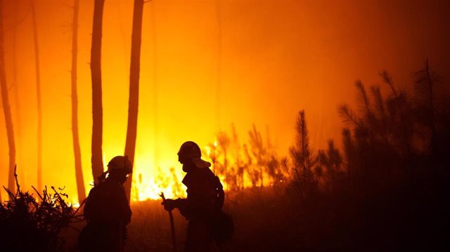 Dos bomberos trabajan en el incendio, a 5 agosto de 2022, en O Vento, parroquia de Cea, en la comarca de Salnes y el concello de Villagarcía de Arousa, Pontevedra, Galicia.