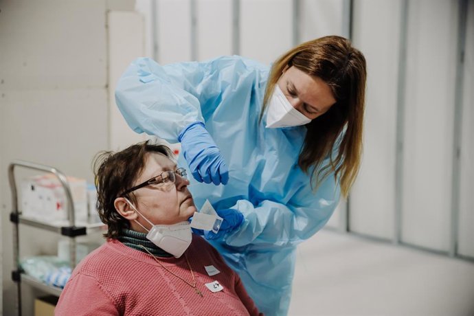 Archivo - Una sanitaria realiza pruebas Covid a personas refugiadas, a su llegada al Hospital Isabel Zendal, a 16 de marzo de 2022, en Madrid (España). Este grupo de personas ucranianas ha llegado a España gracias al convoy humanitario de la Fundación d