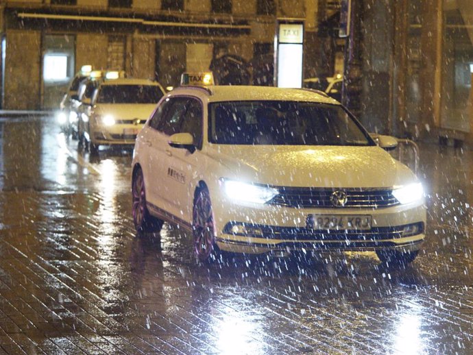 Archivo - Un coche circula bajo la lluvia en Pamplona