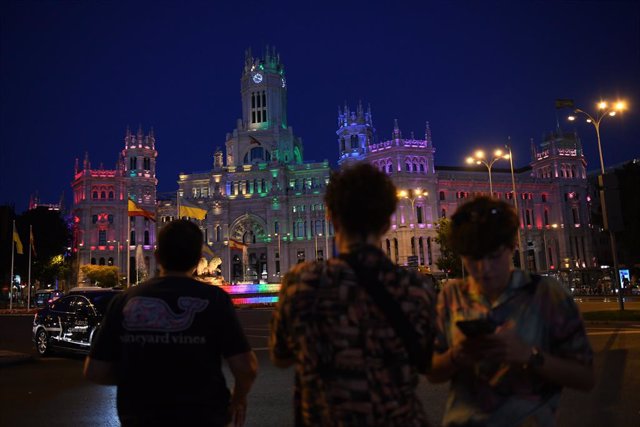 Archivo - Varias personas frente a la fuente y el Palacio de Cibeles con los colores de la bandera LGTB, a 6 de julio de 2022, en Madrid (España). Con motivo del #OrgulloMadrid2022, el Palacio de Cibeles, sede del Ayuntamiento de Madrid, se encuentra ilum