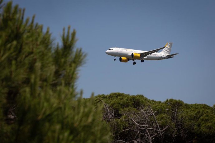 Archivo - Un avió sobrevola l'aeroport de Barcelona