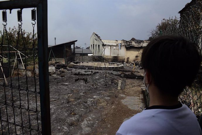 Un vecino observa una zona de viviendas afectadas por el fuego, a 18 de julio de 2022, en O Barco de Valdeorras, Ourense, Galicia (España). La superficie arrasada por los principales incendios registrados en Galicia ya supera las 9.000 hectáreas, según 