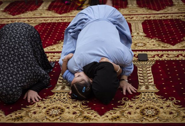 Mujer reza con su hija en el funeral de dos de los musulmanes asesinados en Albuquerque, Nuevo México, Estados Unidos.
