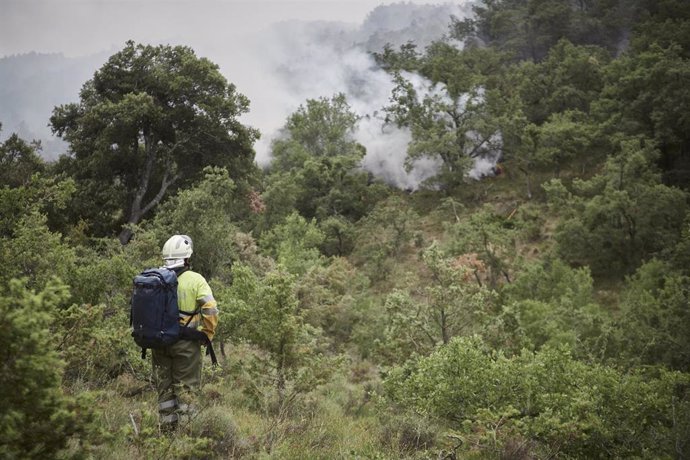 Archivo - Un bombero trabaja en las labores de extinción de uno de los incendios declarados el pasado mes de junio