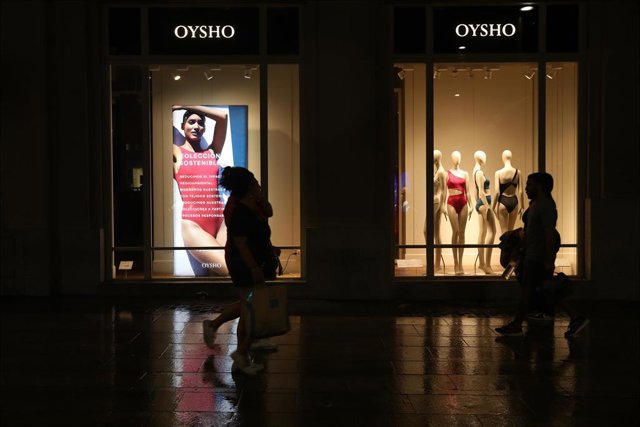 Varias personas caminan frente a un escaparate