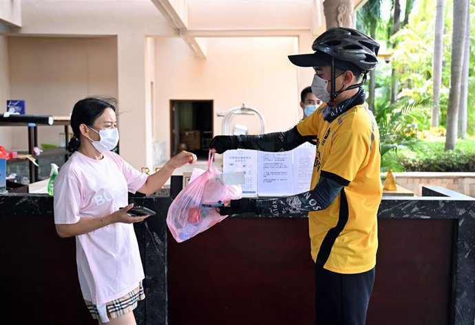 Una turista recibe a un mensajero en un hotel de Sanya, en Hainan