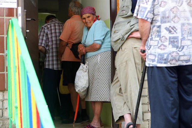 Archivo - Una anciana espera en la cola en un centro en un vecindario del norte donde los voluntarios cocinan comidas calientes gratis para las personas necesitadas varias veces a la semana, Kharkiv, noreste de Ucrania. 