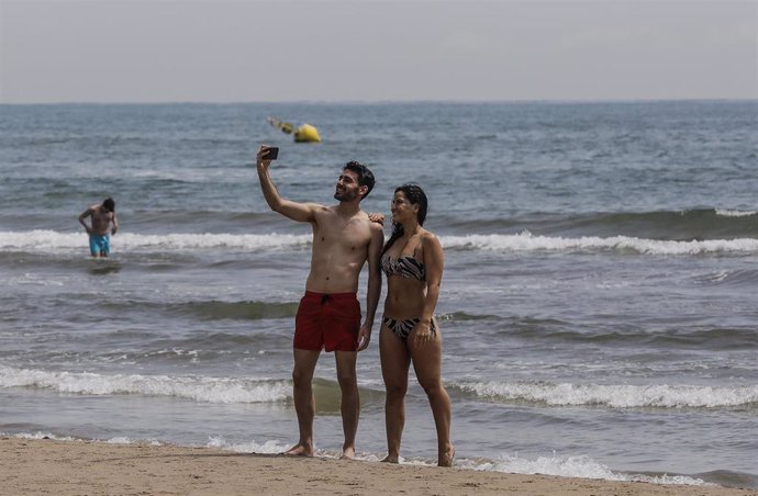 Archivo - Dos personas se hacen un selfie en la Playa de la Malvarrosa